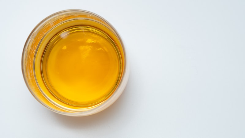 白いテーブルの上に座っている液体で満たされたグラス