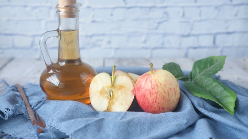 青い布地にスライスしたレモンの横に赤い液体が入った透明なガラス瓶