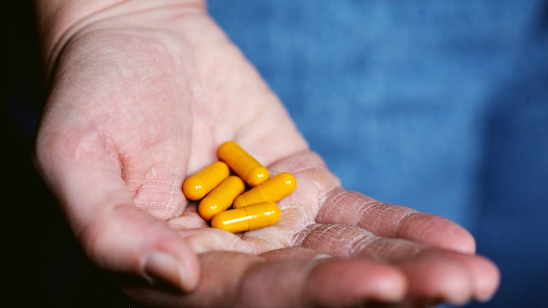 人の手に黄色い薬の丸薬