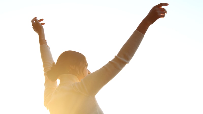 両手を宙に上げた女性