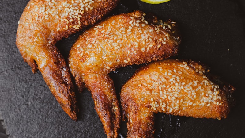 スレートボードにグレープフルーツの半分を添えた手羽先のフライ