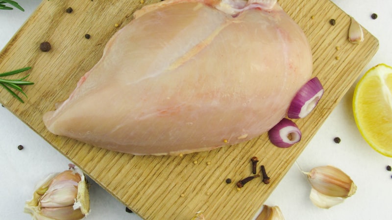まな板の上の生の鶏肉にニンニクレモンニンニクが入った