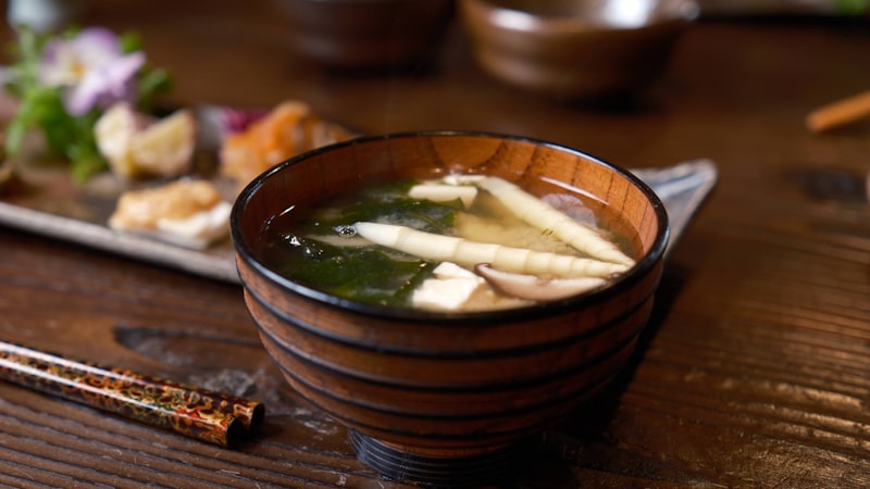 箸の横にスープが入った木製のボウル